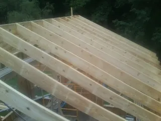 New roof rafters set over an addition before sheathing in New Lisbon
